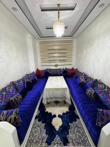 a room with a large blue couch with a table at Martil in Martil
