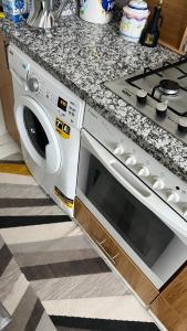 a kitchen counter with a stove and a microwave at Martil in Martil