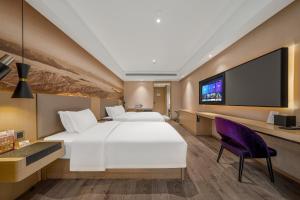 a hotel room with a large bed and a flat screen tv at Mercure Chengdu Downtown Hotel in Chengdu