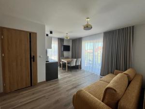 a living room with a couch and a table at Diament Apartamenty in Rowy