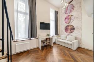 a living room with a couch and a table at Lumiere 28 Aparthotel in Łódź +35 photos