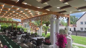 a patio with tables and chairs under a pergola at Olymp Hotel in Magdeburg