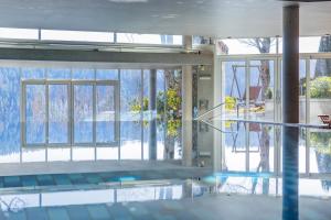 a swimming pool with a view of the outside of a building at Hotel Ramsauhof Zimmer Appartement Pool & Wellness in Ramsau am Dachstein
