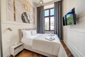 a bedroom with a bed and a tv and a window at Lumiere 28 Aparthotel in Łódź