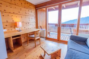 a living room with a desk and a couch at Hotel Ramsauhof Zimmer Appartement Pool & Wellness in Ramsau am Dachstein