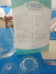 a table with a wine glass and a menu at Hotel Adriatico in Bellaria-Igea Marina