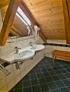 a bathroom with two sinks and a wooden ceiling at DIRNDL Kammer in Abtenau +39 photos