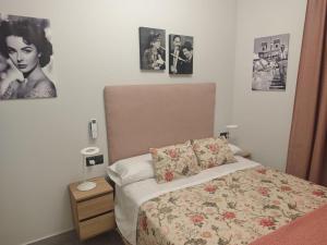 a bedroom with a bed and pictures on the wall at AniCa III De Cine in Tomelloso
