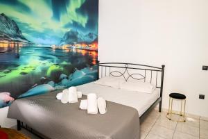a bedroom with a bed with a painting on the wall at Le Bel Appartement D'Antigoni in Alexandroupoli