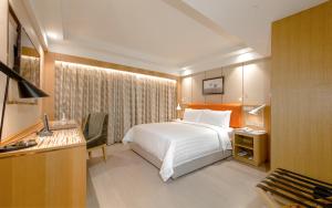 ein Hotelzimmer mit Bett und Schreibtisch in der Unterkunft Royal Dragon Hotel in Macau + 25 Fotos