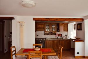 a kitchen with a wooden table and a dining room at La Maison de Nocent in Pré-Saint-Didier