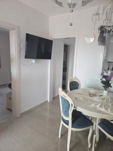a white dining room with a table and chairs at Apartment sofia sea view in Nea Vrasna