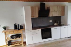 a kitchen with white cabinets and a stove top oven at 20 Min nach Interlaken in Frutigen