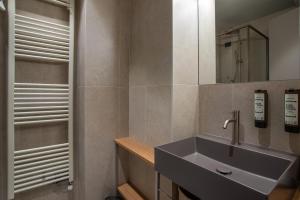 ein Badezimmer mit Waschbecken und Spiegel in der Unterkunft Hotel Costa Azzurra in Grado + 47 Fotos