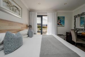 een slaapkamer met een groot wit bed en een bureau bij Harbour House Hotel - Harbour Square in Hermanus +26 foto's