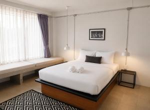 a bedroom with a bed with two stuffed animals on it at Palmari Boutique Hotel in Ban Nua Khlong