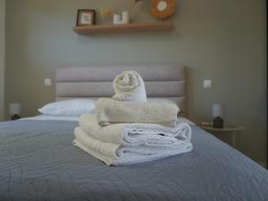 a pile of towels sitting on top of a bed at Johnhara Studios & Apartments in Ialysos +142 photos