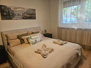 a bedroom with a bed with two towels on it at Borisz Apartman in Makó