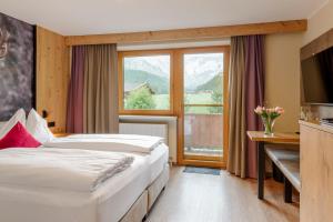 a hotel room with two beds and a window at Boutiquehotel Acherl in Achenkirch +231 photos