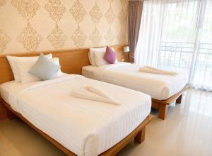two beds in a hotel room with white sheets at Palmari Boutique Hotel in Ban Nua Khlong +106 photos