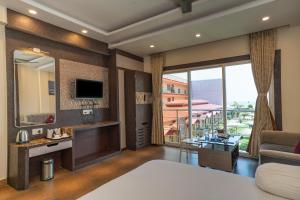 a bedroom with a living room with a large window at Sher Bengal Beach Resort in Mandarmoni