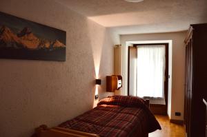 a bedroom with a bed in a room with a window at La Maison de Nocent in Pré-Saint-Didier