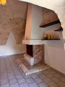a kitchen with a brick fireplace in a room at Giardino dei Trulli Cummerse in Faccia di Trippa di Monte