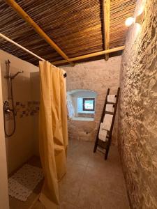 a bathroom with a shower and a shower curtain at Giardino dei Trulli Cummerse in Faccia di Trippa di Monte