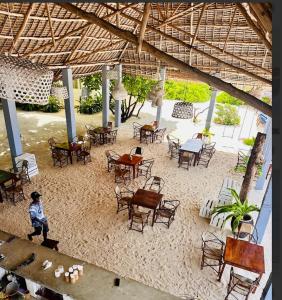 a group of tables and chairs in a building at Garden Beach Bungalows Jambiani in Jambiani