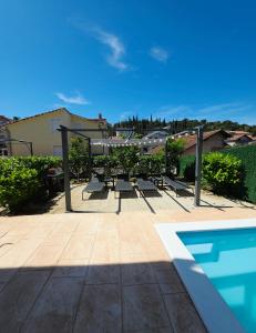 a patio with a table and a swimming pool at Beautiful Holiday Home "Villa Relax Oasis" in Trogir
