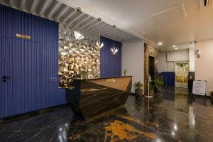 a lobby with a blue wall and a wooden counter at The Belmonte House by Noventa - Rooftop Pool Hotel in Udaipur in Udaipur