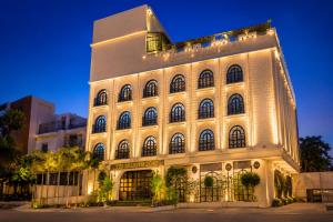 a large white building with lights on it at The Belmonte House by Noventa - Rooftop Pool Hotel in Udaipur in Udaipur