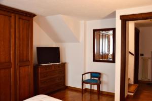 a bedroom with a bed and a tv and a chair at La Maison de Nocent in Pré-Saint-Didier