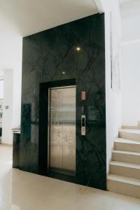 a door in a building with stairs next to it at De La Charis Hotel in Kediri