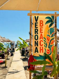 a sign on a beach with a bench and an umbrella at Villa Verona in Durrës +66 photos