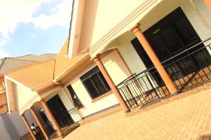 a house with columns and a staircase in front of it at Crown Suites Motel in Masaka