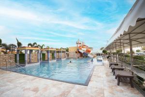 a pool at a resort with people in it at Sher Bengal Beach Resort in Mandarmoni