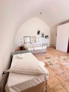 two beds in a room with an arched wall at Giardino dei Trulli Cummerse in Faccia di Trippa di Monte