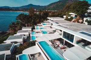 an aerial view of a building with umbrellas and the water at Kata Rocks in Kata Beach