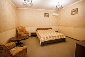 a bedroom with a bed and a table and chairs at Avenue Hotel in Chernivtsi