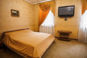 a bedroom with a bed and a flat screen tv at Avenue Hotel in Chernivtsi +35 photos