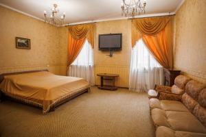 a bedroom with a bed and a tv and a couch at Avenue Hotel in Chernivtsi
