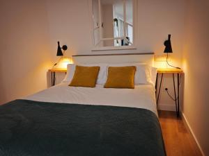 a bedroom with a large white bed with two lamps at Judería Suite Jaén in Jaén