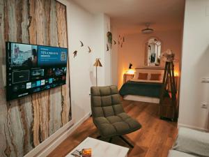 a living room with a tv and a bedroom at Judería Suite Jaén in Jaén