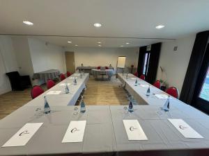 a conference room with a long table and chairs at The Originals City, Hôtel Le Gayant, Douai in Douai