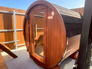 a wooden sauna with a glass door on a roof at Calme Villa in Asahi