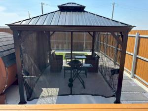 a gazebo with a table in it on a roof at Calme Villa in Asahi