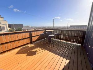 a deck with two chairs and a table on it at Calme Villa in Asahi