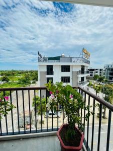 a balcony with a plant in front of a building at A90 HOTEl2 in Nhật Tựu