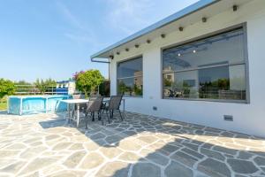 a patio with chairs and a table next to a building at Green Galini Villa Pelion - the small unit in Platanidia